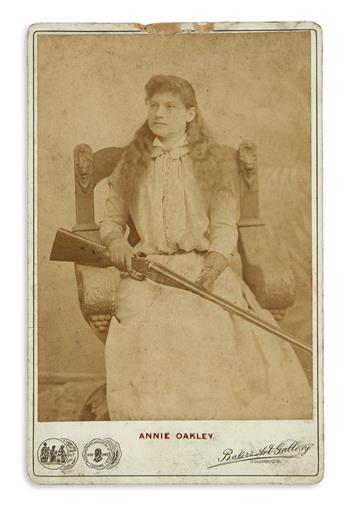 OAKLEY, ANNIE. Photograph Signed and Inscribed, Compliments, on verso of cabinet card half-length portrait by Bakers Art Gallery,